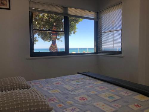 Somerton ParkThe Somerton Beach Retreat的一间卧室设有一张床和一个海景窗户