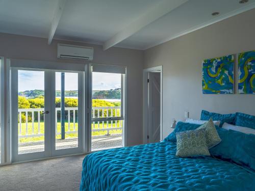 史密斯海滩1-bedroom unit with balcony and ocean views!的一间卧室设有蓝色的床和一个阳台