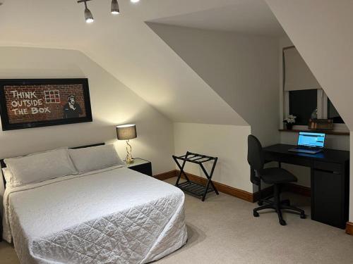 The Jagdamer Lodge的一间卧室配有一张床和一张带笔记本电脑的书桌