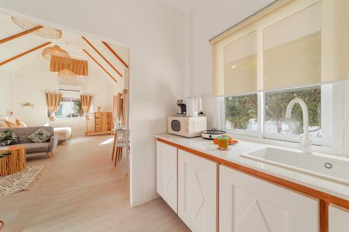 通萨拉Sunset Lover Beach Residence的白色的厨房设有水槽和窗户