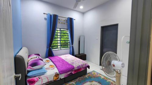 淡马鲁Homestay D Paya Jauh的一间带一张床和风扇的小卧室