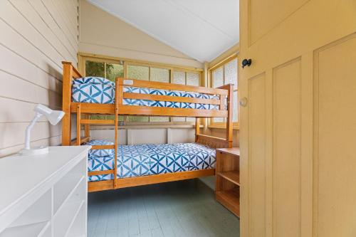 纳鲁马The Seamist Cottage的房屋内设有一间带两张双层床的卧室