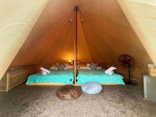 佩纳利克村Rembulan Escape - beachfront bell tent (no 1)的一个带绿床的帐篷