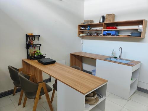 芹苴Nhà nghỉ Bonne Vie' Homestay的厨房配有木桌和水槽。