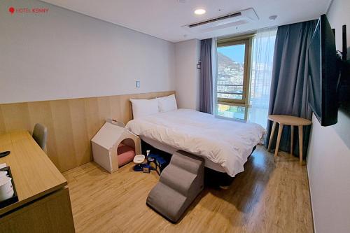 丽水市Hotel Kenny Yeosu的小房间设有床和窗户