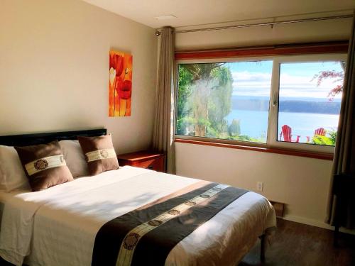 坎贝尔河Ocean's Edge Suite的一间卧室设有一张床和一个大窗户
