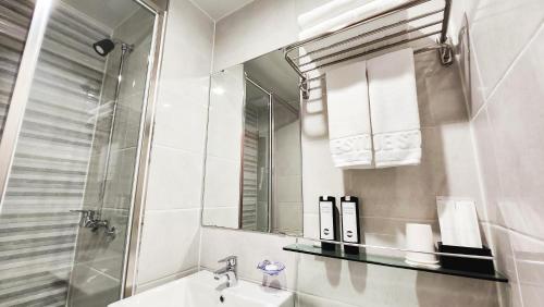 釜山Haeundae Blue Story Hotel的白色的浴室设有水槽和镜子