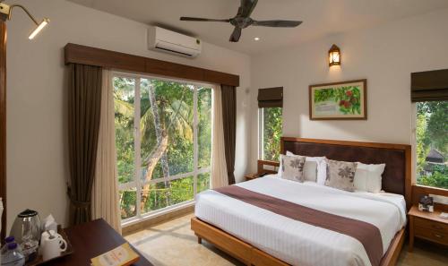 瓦亚纳德Jeevess Ayurveda Resort的一间卧室设有一张床和一个大窗户