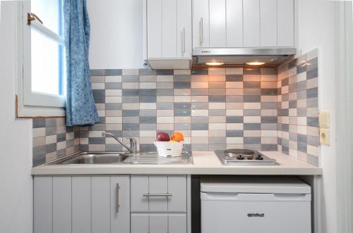 纳克索乔拉加拉兹雅公寓的厨房配有白色橱柜和水槽