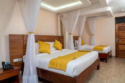 奈瓦沙伯奇奈瓦沙度假村的一间卧室配有两张带黄色枕头的床