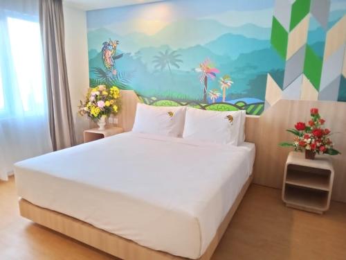 查亚普拉MaxOneHotels at Jayapura的卧室配有一张白色大床和壁画