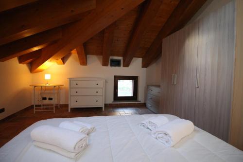 布吕松Attico dell'Aquila的卧室配有带毛巾的大型白色床