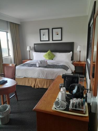 哈里史密斯Protea Hotel by Marriott Harrismith Montrose的酒店客房配有一张床铺和一张桌子。