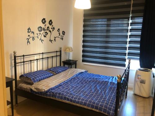 伯萨Hallmark Bursa的一间卧室配有一张带蓝色床单的床和一扇窗户。