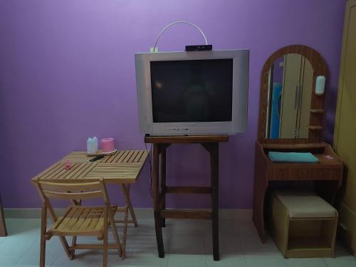 芭东海滩Baan Nakarin Guest House บ้านนครินทร์的客厅配有电视和桌椅