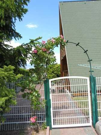 于克里茨Ferienhaus _Achterblick_ Gerlinde的房屋旁的围栏,门上挂着玫瑰花