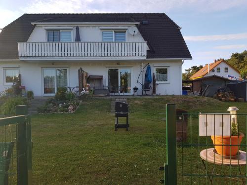LütowFerienwohnung am Teich的院子内有栅栏的白色房子