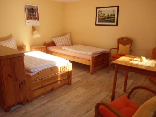 NeuenkirchenFerienwohnung Familie Maas的一间设有两张床和一张桌子及椅子的房间