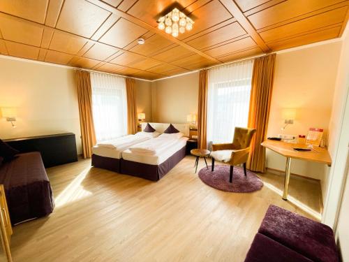 奥格斯堡城市东部酒店的配有一张床和一张书桌的酒店客房