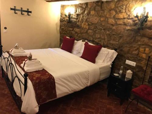 拉瓜迪亚La Posada de Leza的一间卧室配有一张大床,配有白色床单和红色枕头
