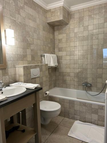 泽布吕赫阿特拉斯酒店的浴室配有卫生间、浴缸和水槽。