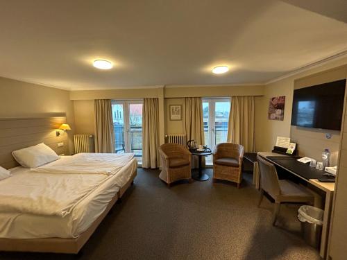 泽布吕赫阿特拉斯酒店的配有一张床和一张书桌的酒店客房