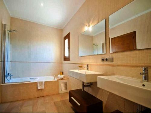 阿尔库迪亚Finca Santa María的浴室设有2个水槽、浴缸和镜子