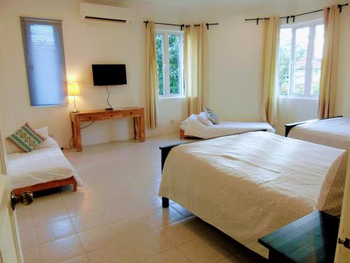 雪邦Rumah Putih B&B near KLIA的一间卧室配有两张床和电视。