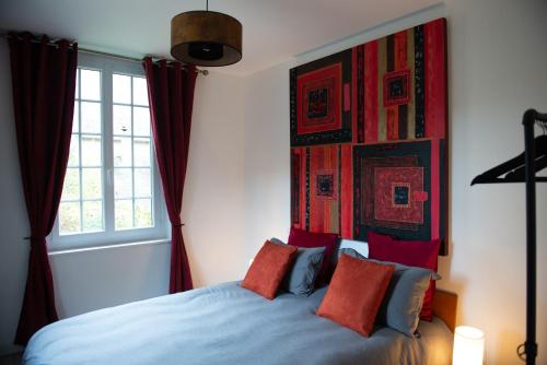 莱桑德利Les Gites By Carpe Diem的一间卧室配有蓝色的床和红色枕头