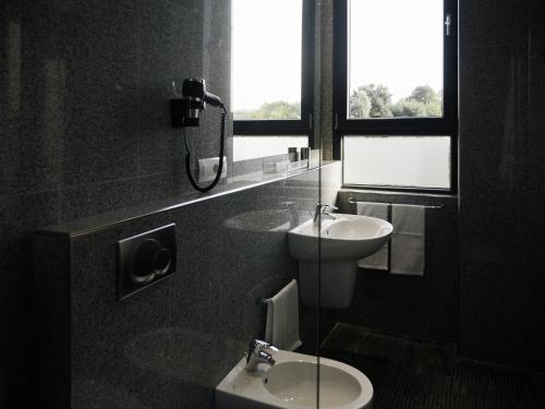 罗马Loto Business Hotel的一间带水槽和卫生间的浴室以及窗户。
