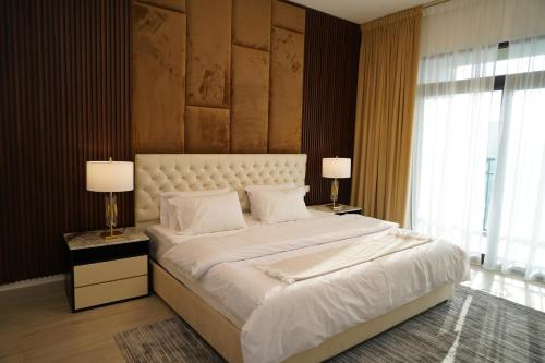 迪拜Madinat Jumeirah Living的一间卧室配有一张带两盏灯的大型白色床。