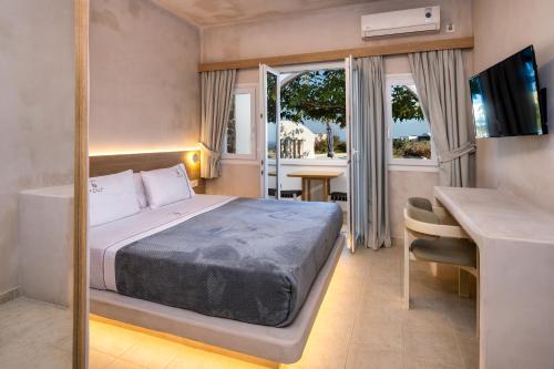 卡特瑞杜斯Aelia Luxury Suites的一间卧室配有一张床、一张书桌和一个窗户。