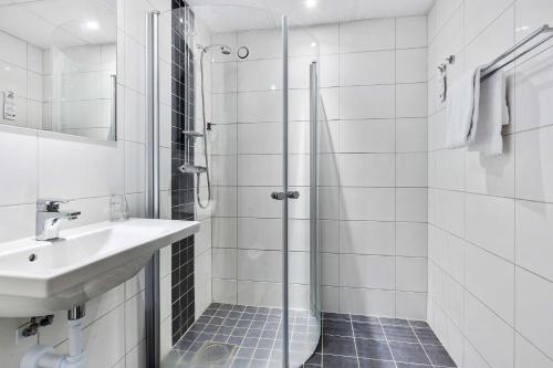 雪平舍勒贝斯特韦斯特酒店的带淋浴和盥洗盆的白色浴室