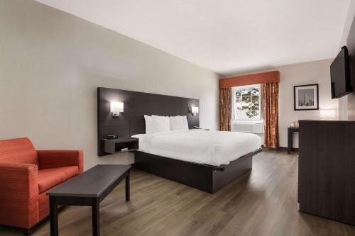 塔尔萨I-44品质套房酒店的配有一张床和一把椅子的酒店客房