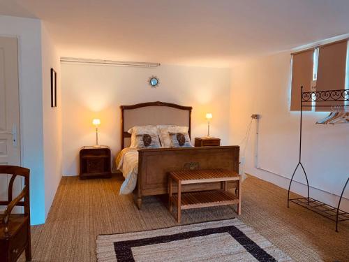 孔东VILLA PIERRE的一间卧室配有一张带两盏灯和一张桌子的床。