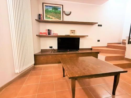 安达洛Appartamento LO SCOIATTOLO的客厅设有木桌和楼梯。