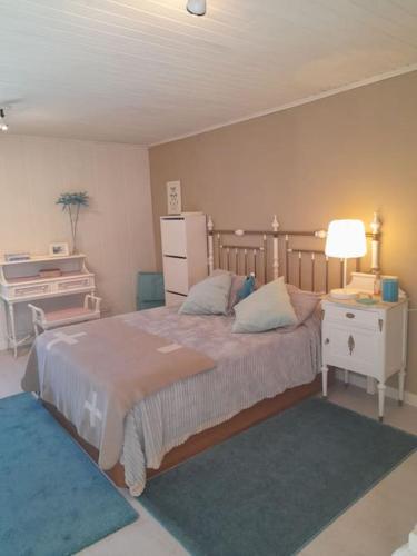 艾斯特拉达Agradable casa rural en Galicia的一间卧室配有一张大床、一张桌子和一盏灯。