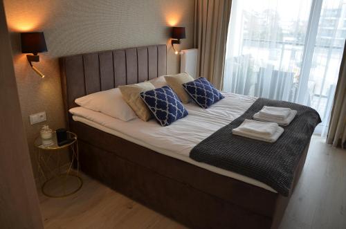 科沃布热格Westin House Resort Kołobrzeg Apartament DELUX的一张带蓝色和白色枕头的床和窗户