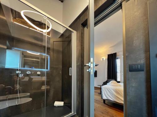 巴勒莫Gioiamia - Luxury Rooms in Cattedrale的一间带玻璃淋浴间的浴室和一间卧室