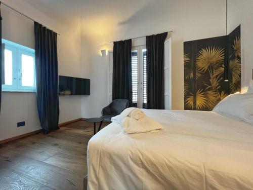 巴勒莫Gioiamia - Luxury Rooms in Cattedrale的一间卧室配有一张床,床上有毛巾