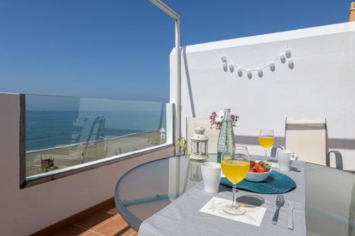 托雷德本纳贾尔邦WintowinRentals Amazing Front Sea View & Relax的阳台上的桌子和两杯葡萄酒