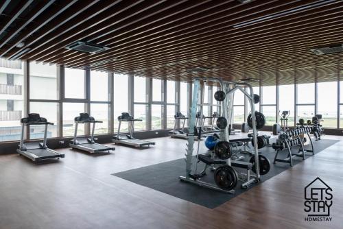 马六甲Bali Premier Suites Melaka的一个带跑步机和举重器械的健身房,位于带窗户的房间内