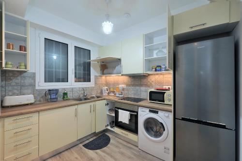 雅典Bella Ciao Guest House的厨房配有冰箱、洗衣机和烘干机