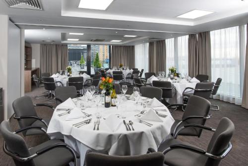 伦敦伦敦西部戴斯酒店的一间会议室,配有白色的桌椅