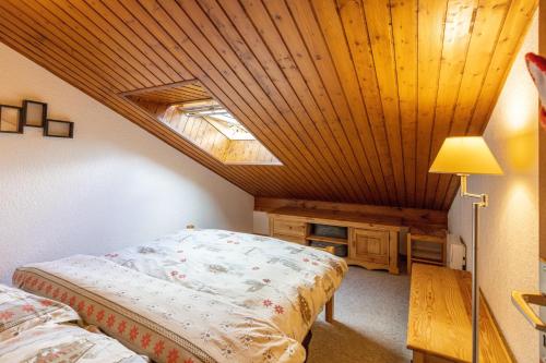 贝勒沃Le Forchat - proche des pistes的一间卧室设有一张床和木制天花板