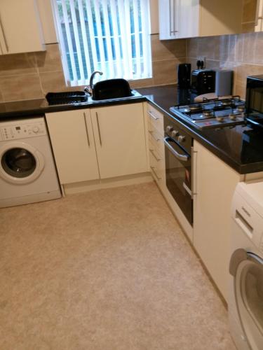 利物浦Sandringham House的一个带水槽和洗碗机的厨房