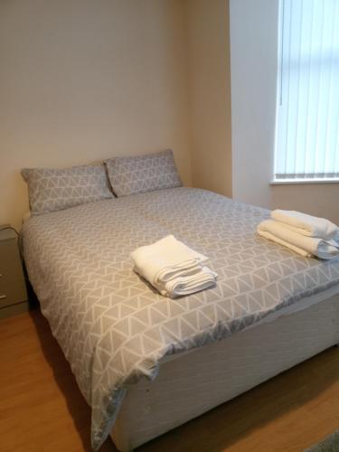 利物浦Sandringham House的床上有两条白色毛巾