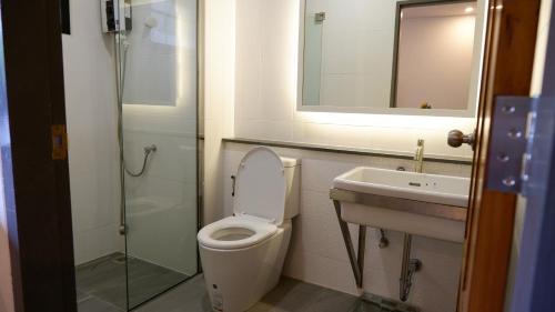 董里Nara Residence Trang的一间带卫生间、水槽和镜子的浴室