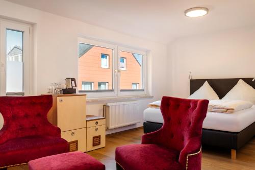 黑尔戈兰岛Helgolandia Dependance的酒店客房,配有一张床和两把椅子