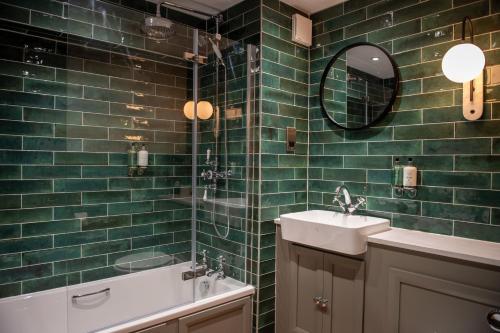 陶德维克The Red Lion Inn by Chef & Brewer Collection的绿色瓷砖浴室设有水槽和镜子
